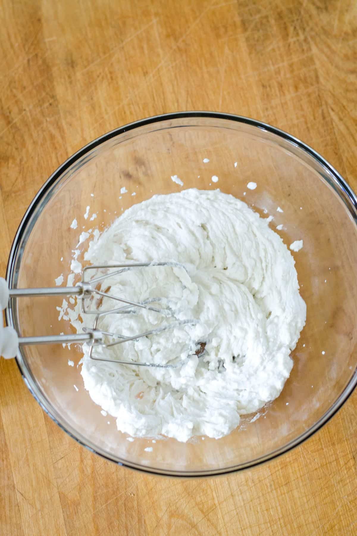 Beaters in bowl of whipped coconut cream