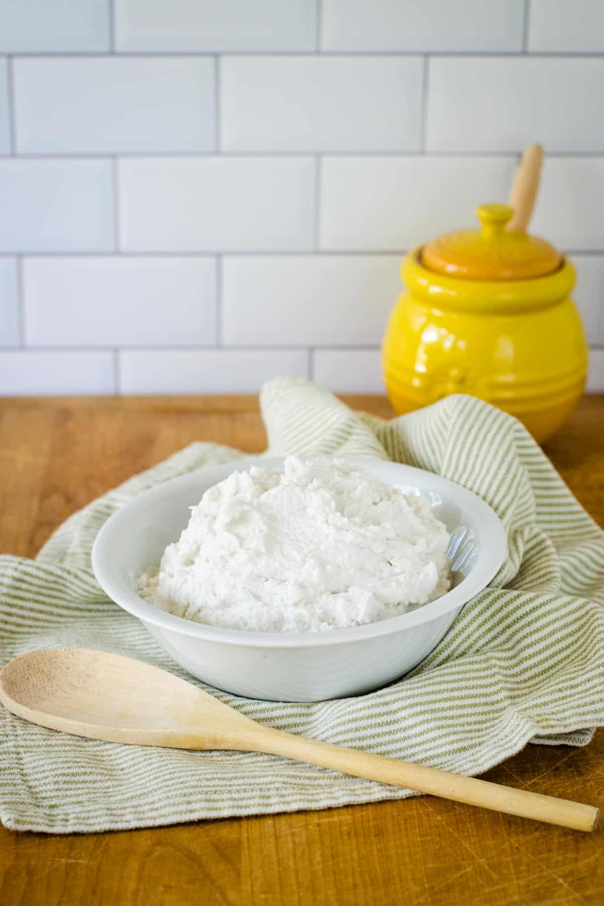 Bowl of whipped coconut cream with spoon and jar
