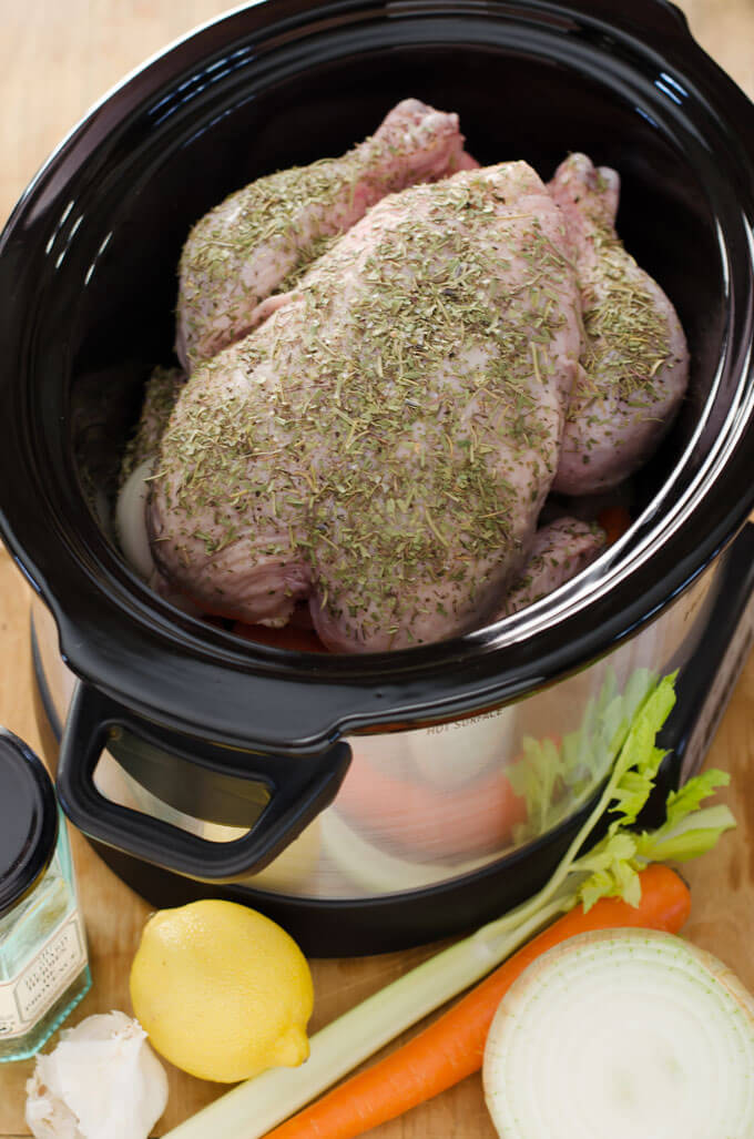 Whole chicken a in slow cooker with vegetables