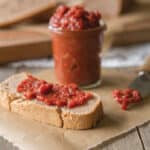 Tomato jam in jar and on slice of bread