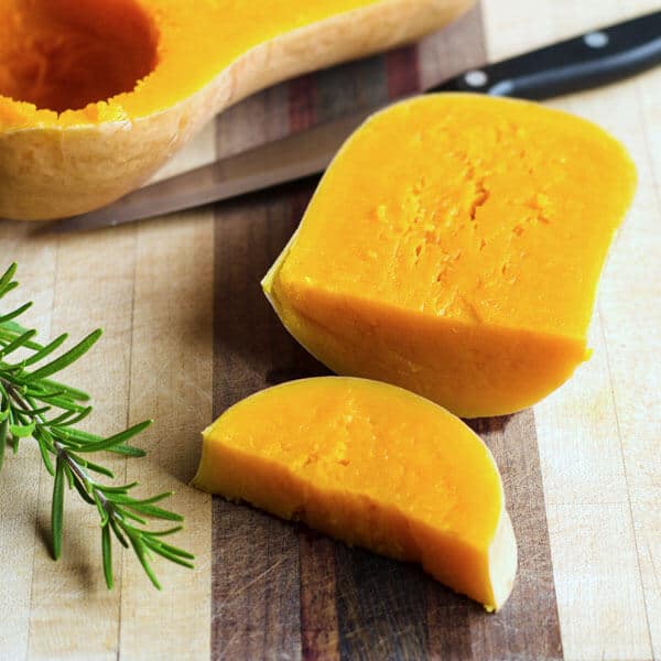 Cooked butternut squash sliced on cutting board