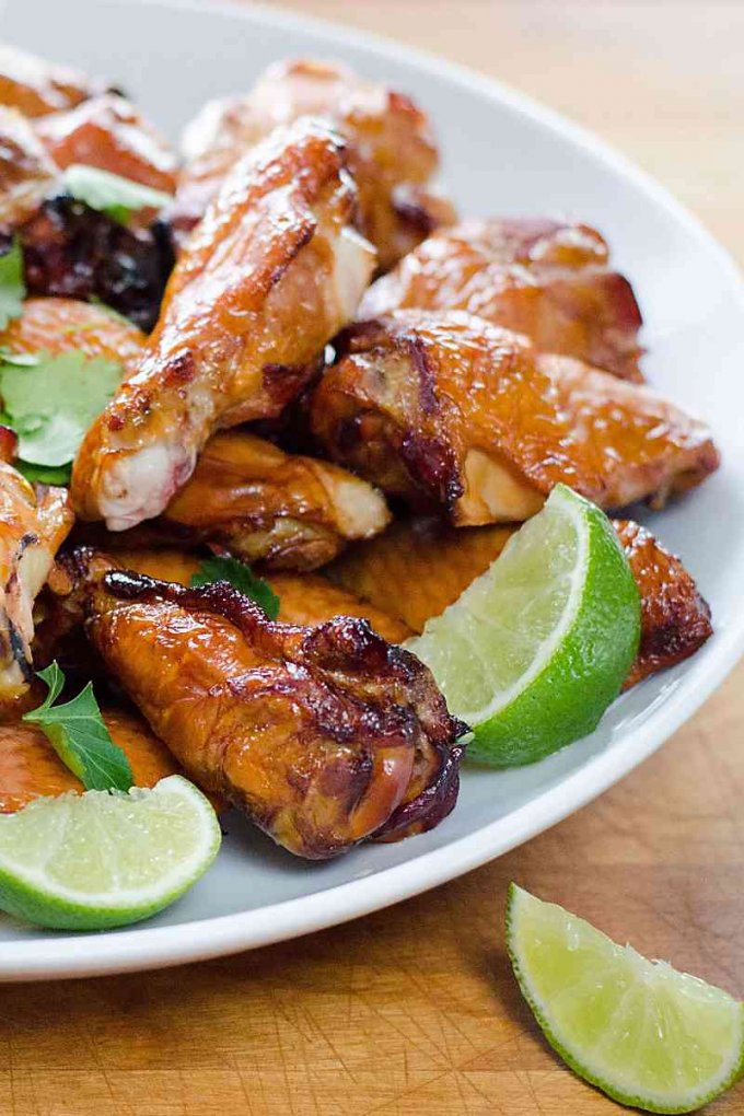 Crispy smoked chicken wings with lime wedges