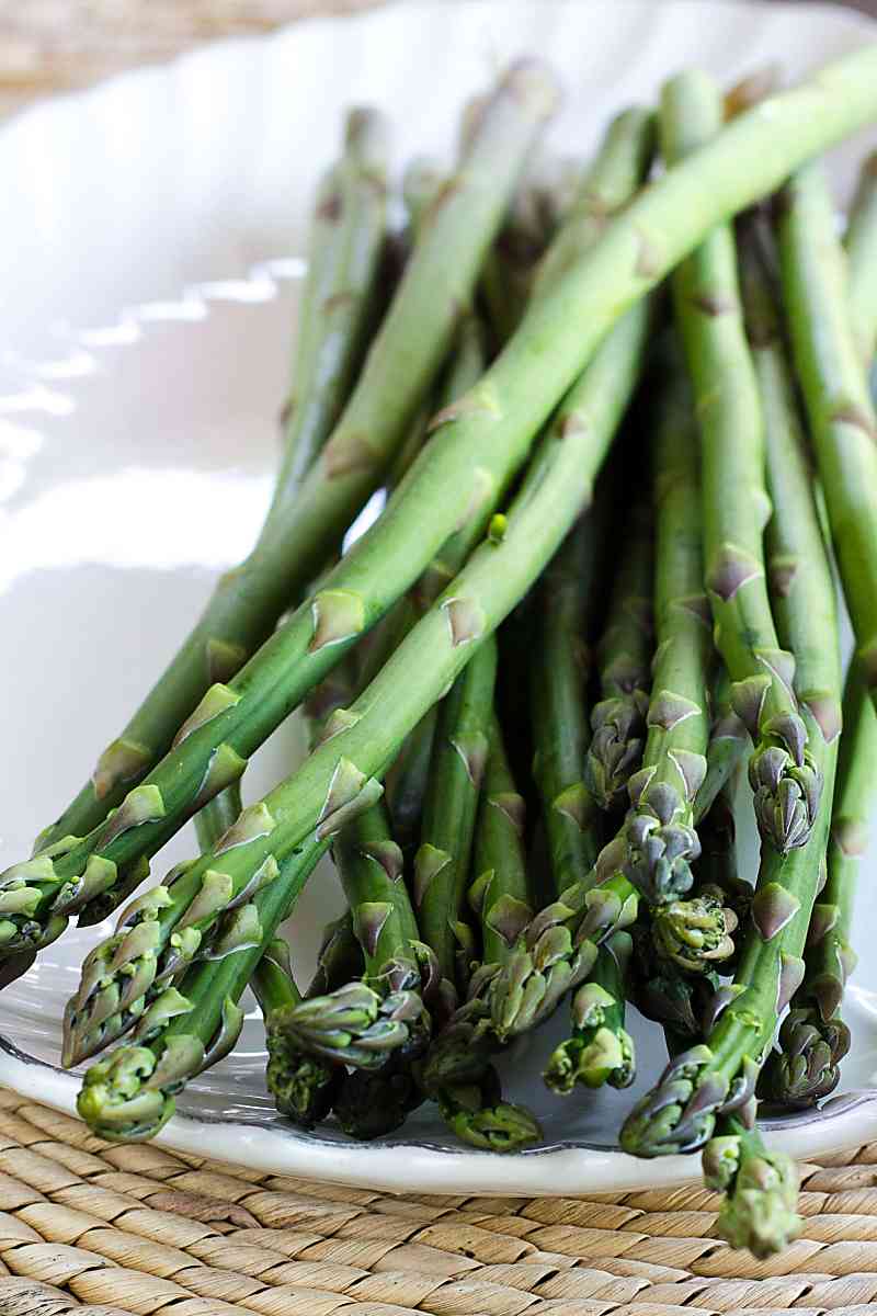 Raw asparagus on white platter