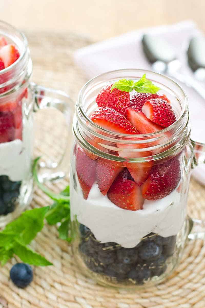 Red, white and blue berries and cream in a mason jar