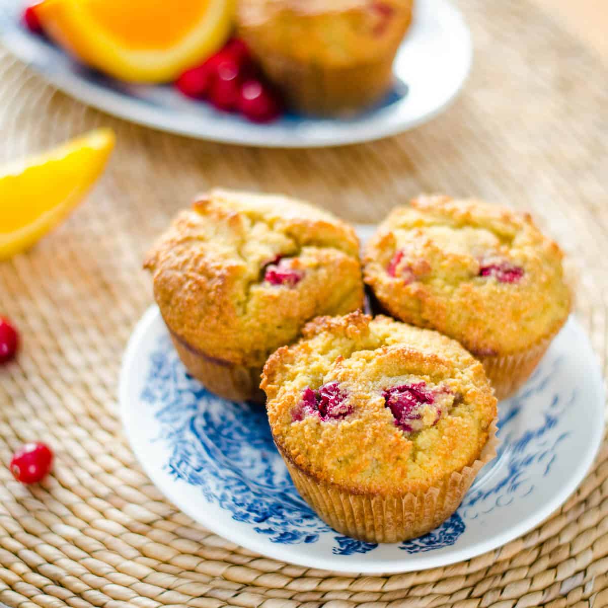 Muffins on plates with orange and cranberries