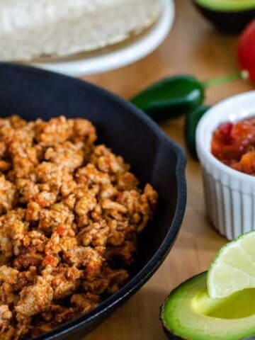 Taco meat in cast iron pan, avocado, salsa