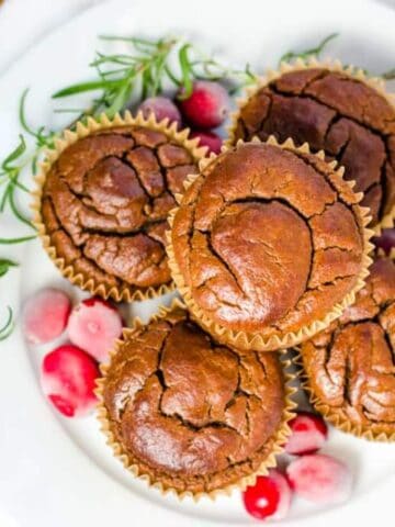 Banana gingerbread muffins on plate with cranberries and rosemary