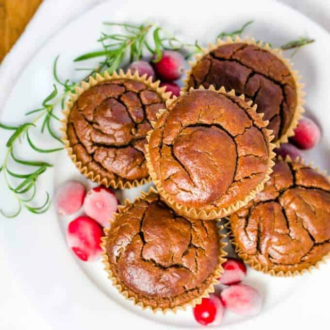 Banana gingerbread muffins on plate with cranberries and rosemary
