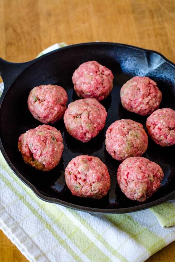 Meatballs ready to bake in cast iron pan