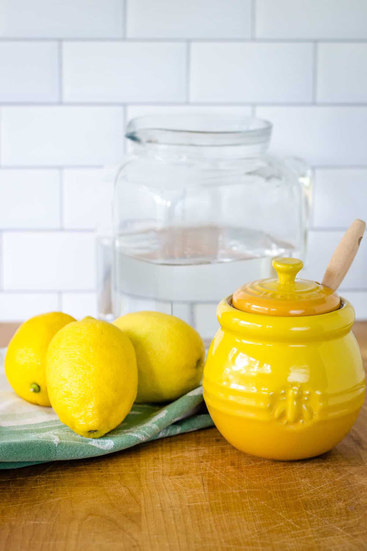 Lemons, honey pot, pitcher of water