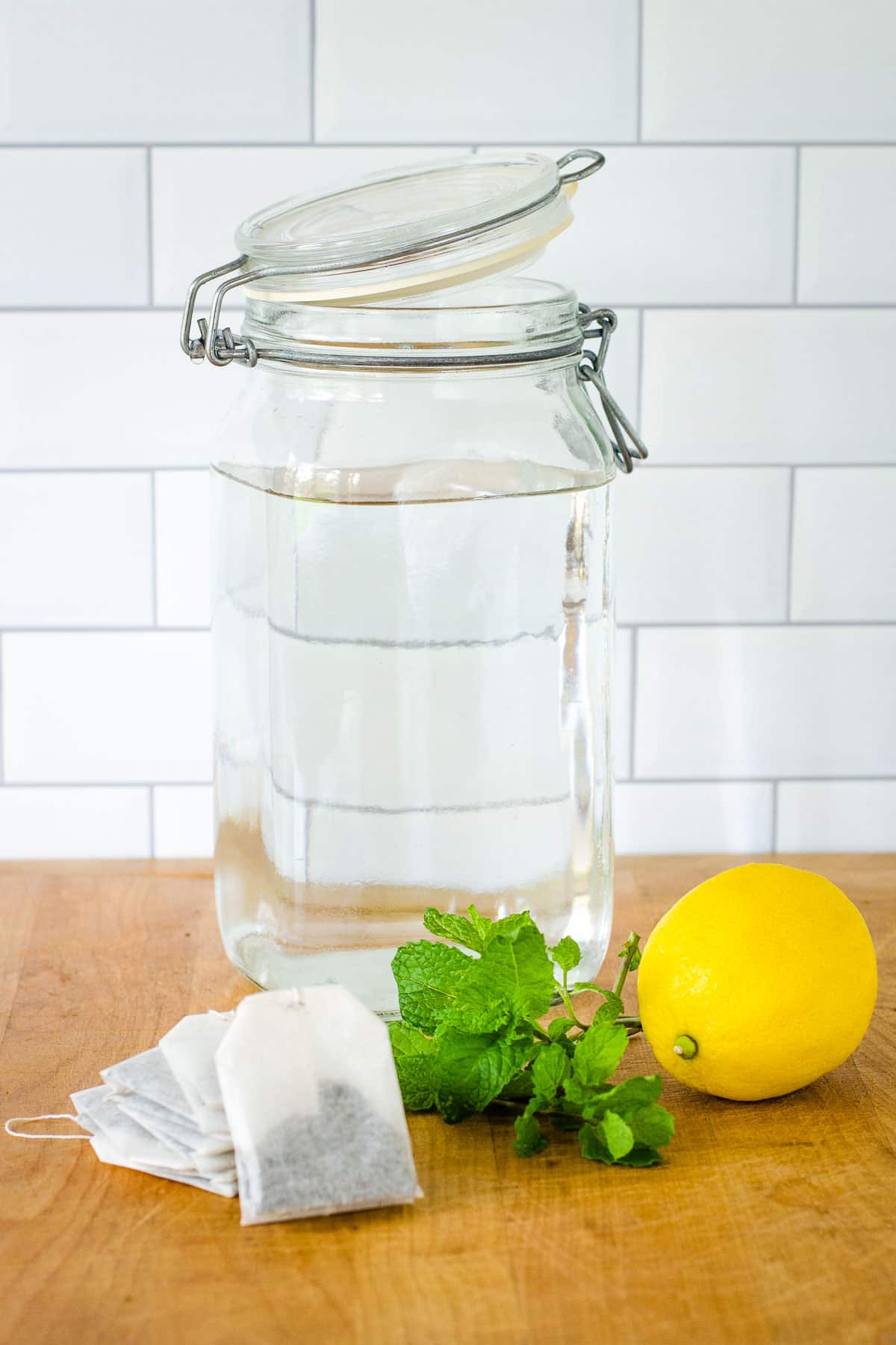 Tea bags, mint leaves, lemon, large jar of water