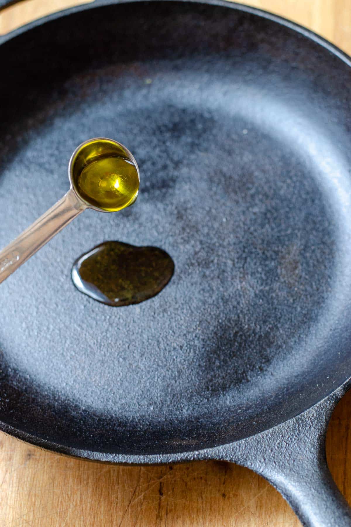 Pouring oil into cast iron skillet