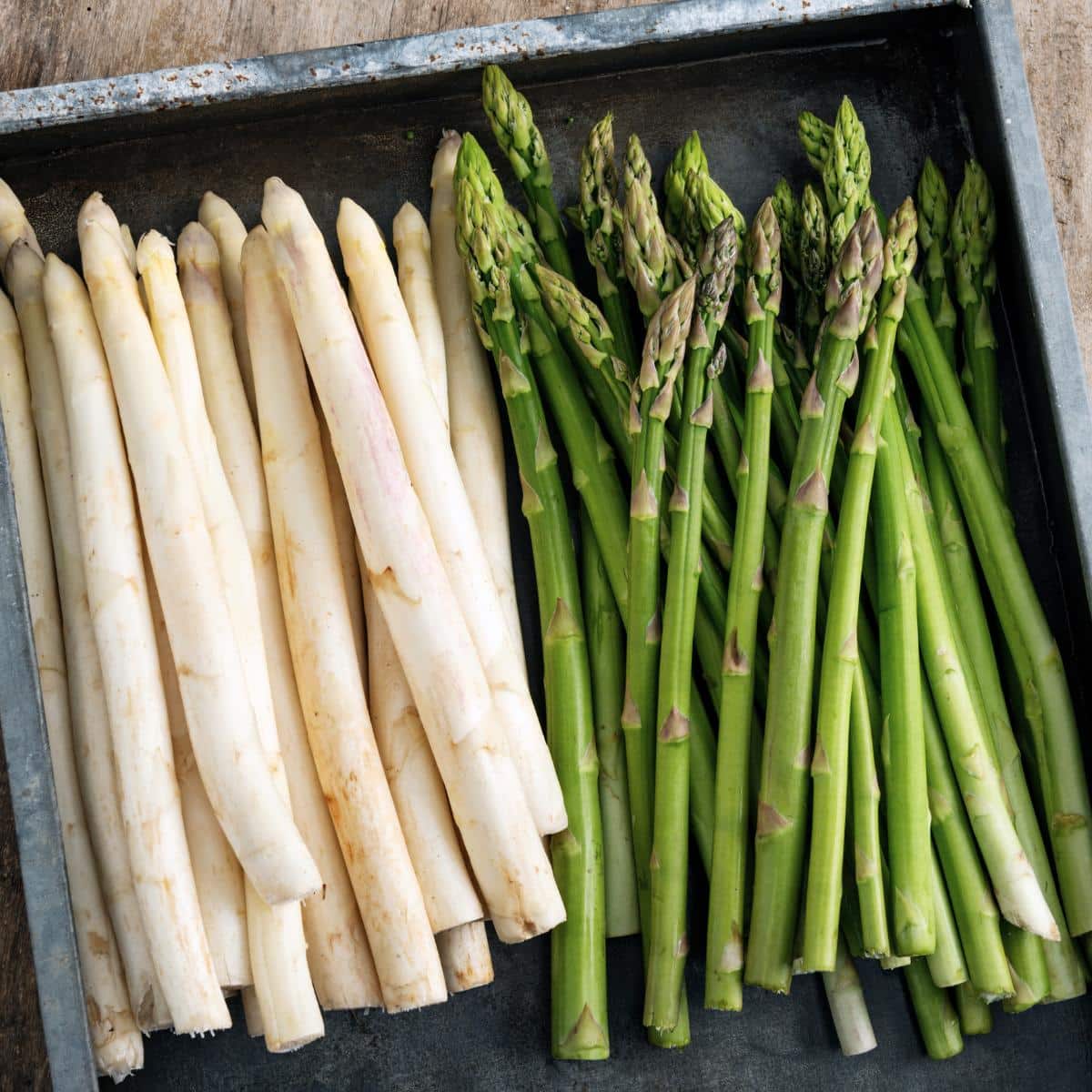 White and green asparagus in metal pan