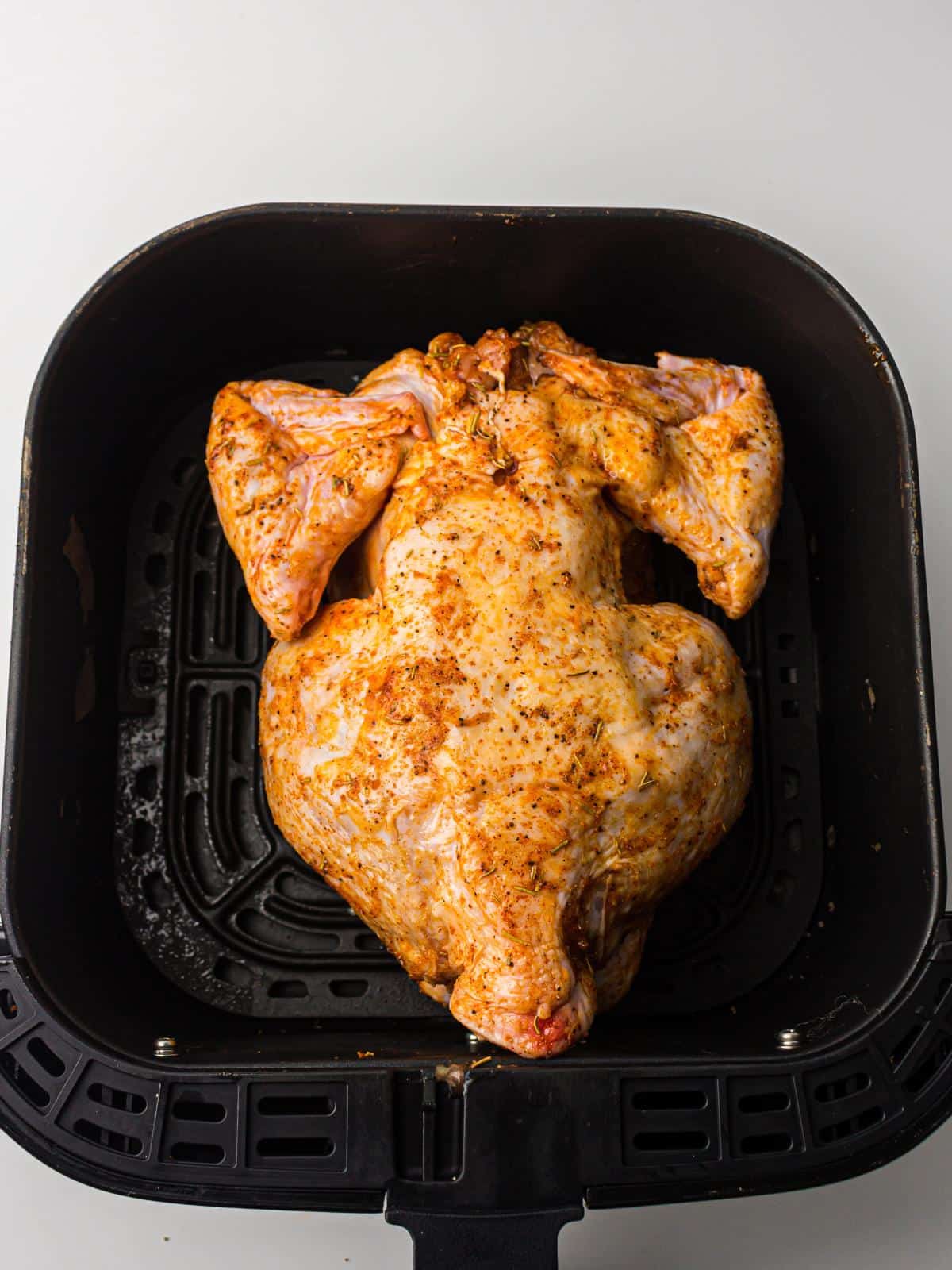 Whole chicken breast side down in air fryer.