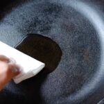 Wiping cast iron pan with oil