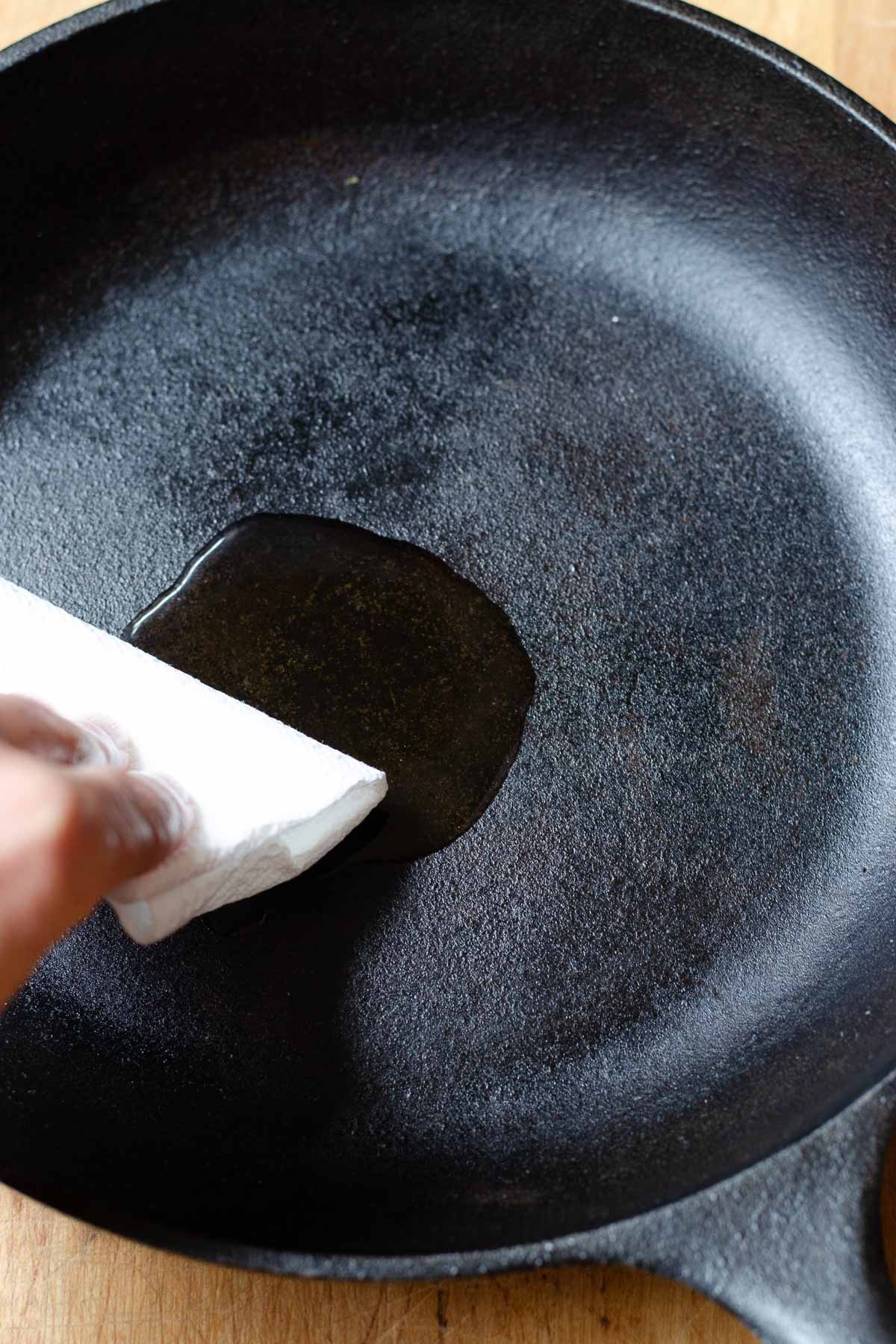 Wiping cast iron pan with oil