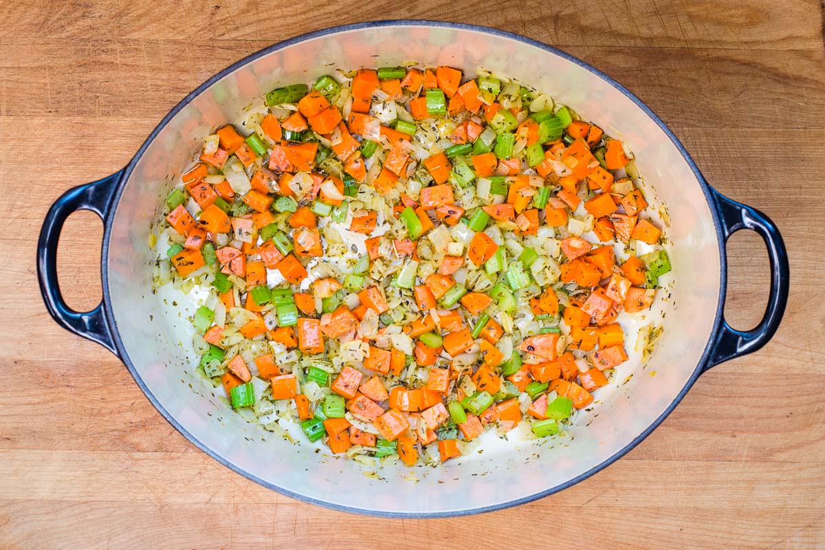 Carrots, celery, onions and herbs cooked in bottom of pot.