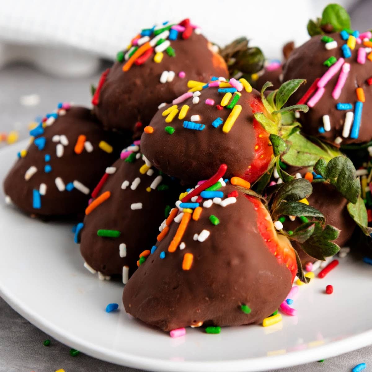Chocolate strawberries on white plate.