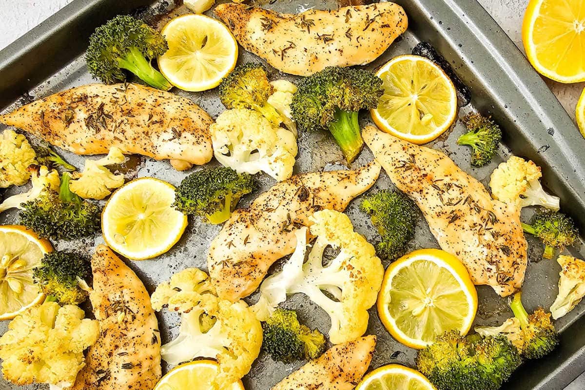 Oven baked sheet pan chicken with broccoli, cauliflower and lemon.