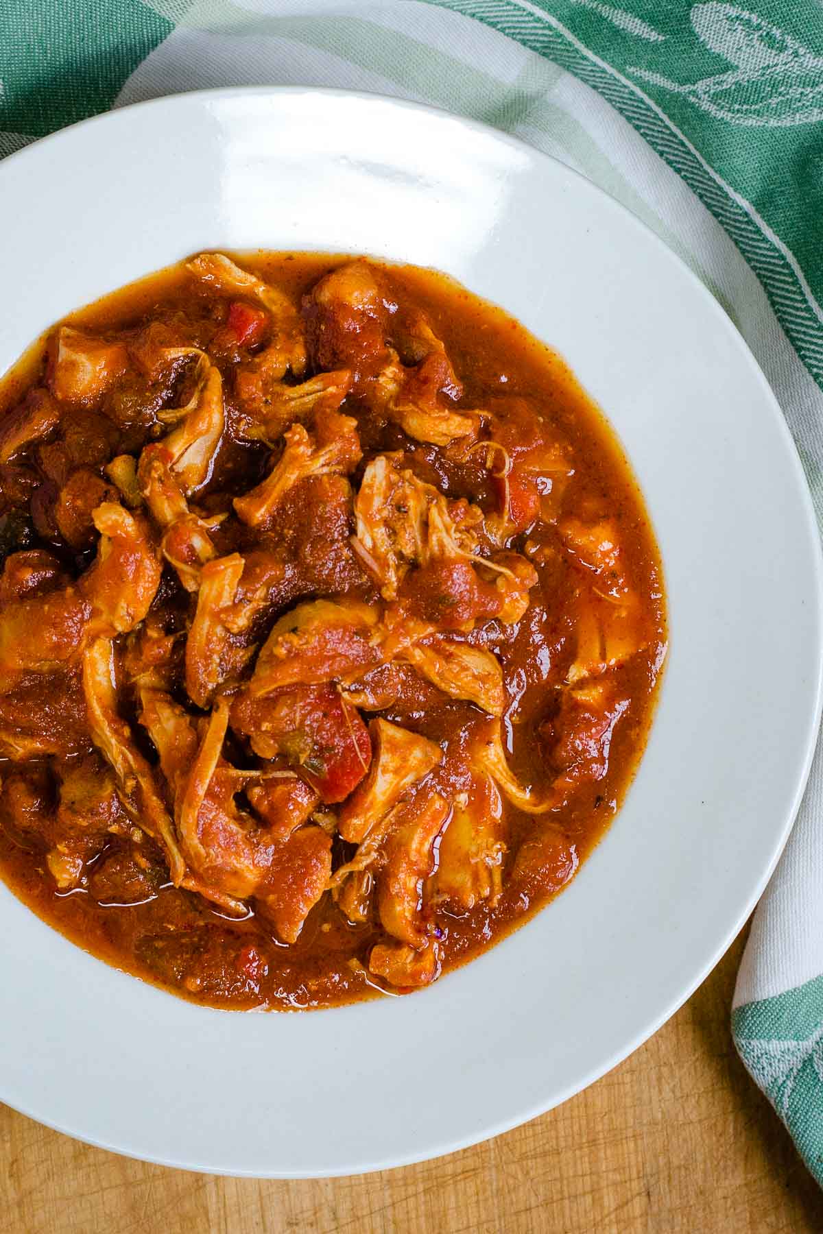 Slow cooker chicken marinara in white bowl.