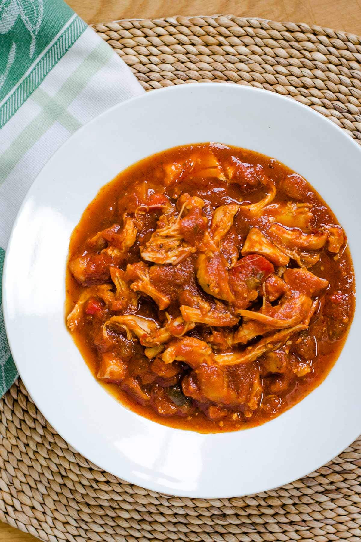 Slow cooker chicken marinara in white bowl.