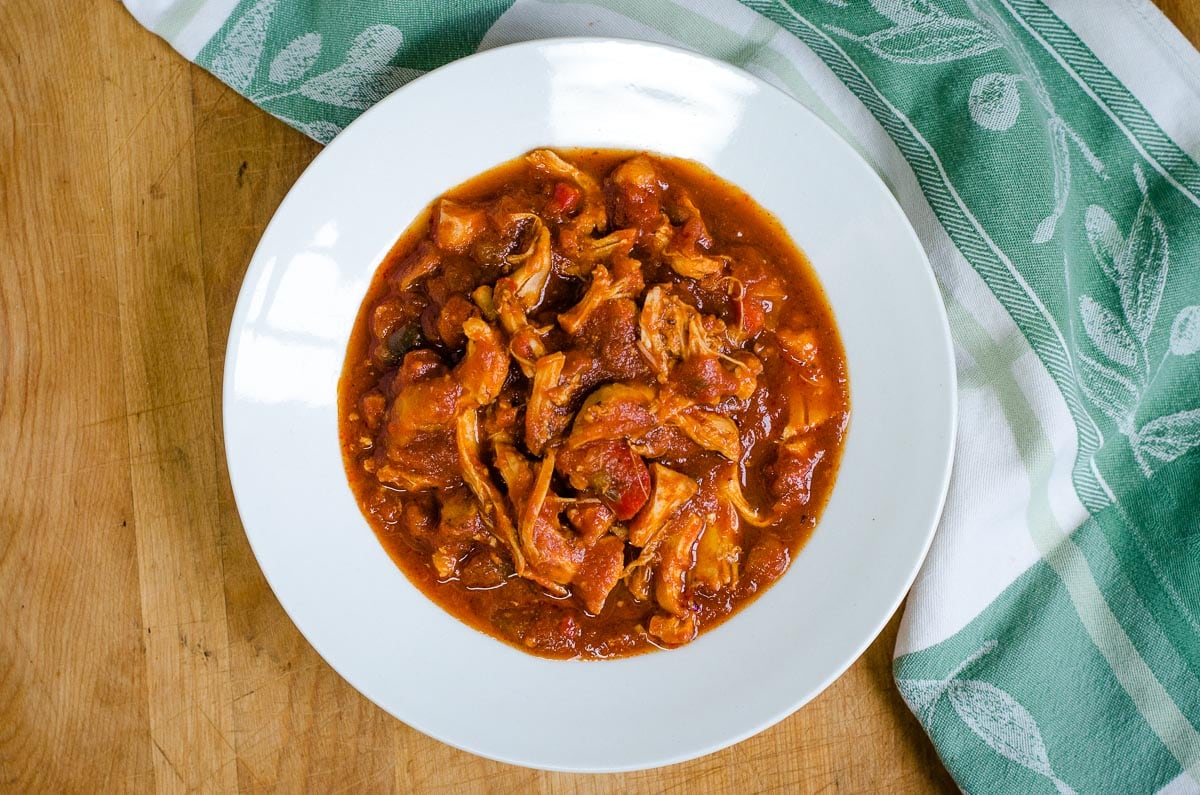 Slow cooker chicken marinara in white bowl.