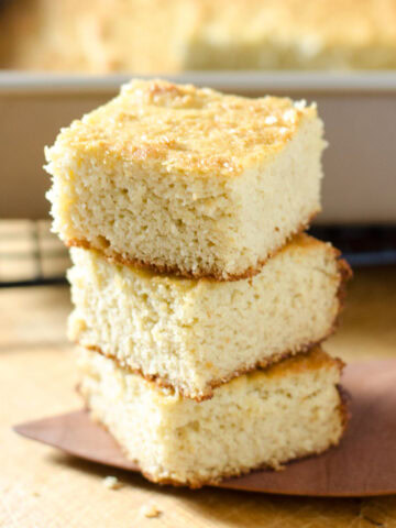 Paleo cornbread squares stacked on top of each other.