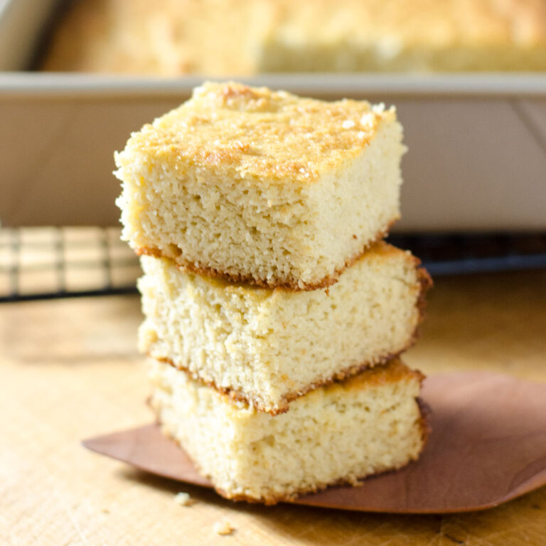 Paleo cornbread squares stacked on top of each other.
