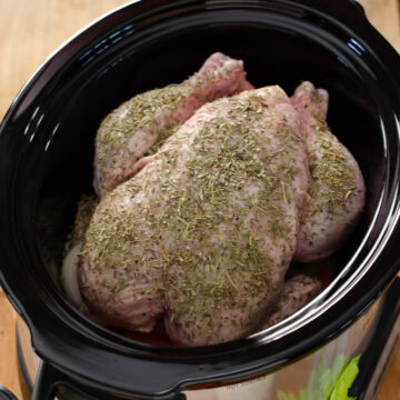 Whole chicken in a crockpot ready to cook.