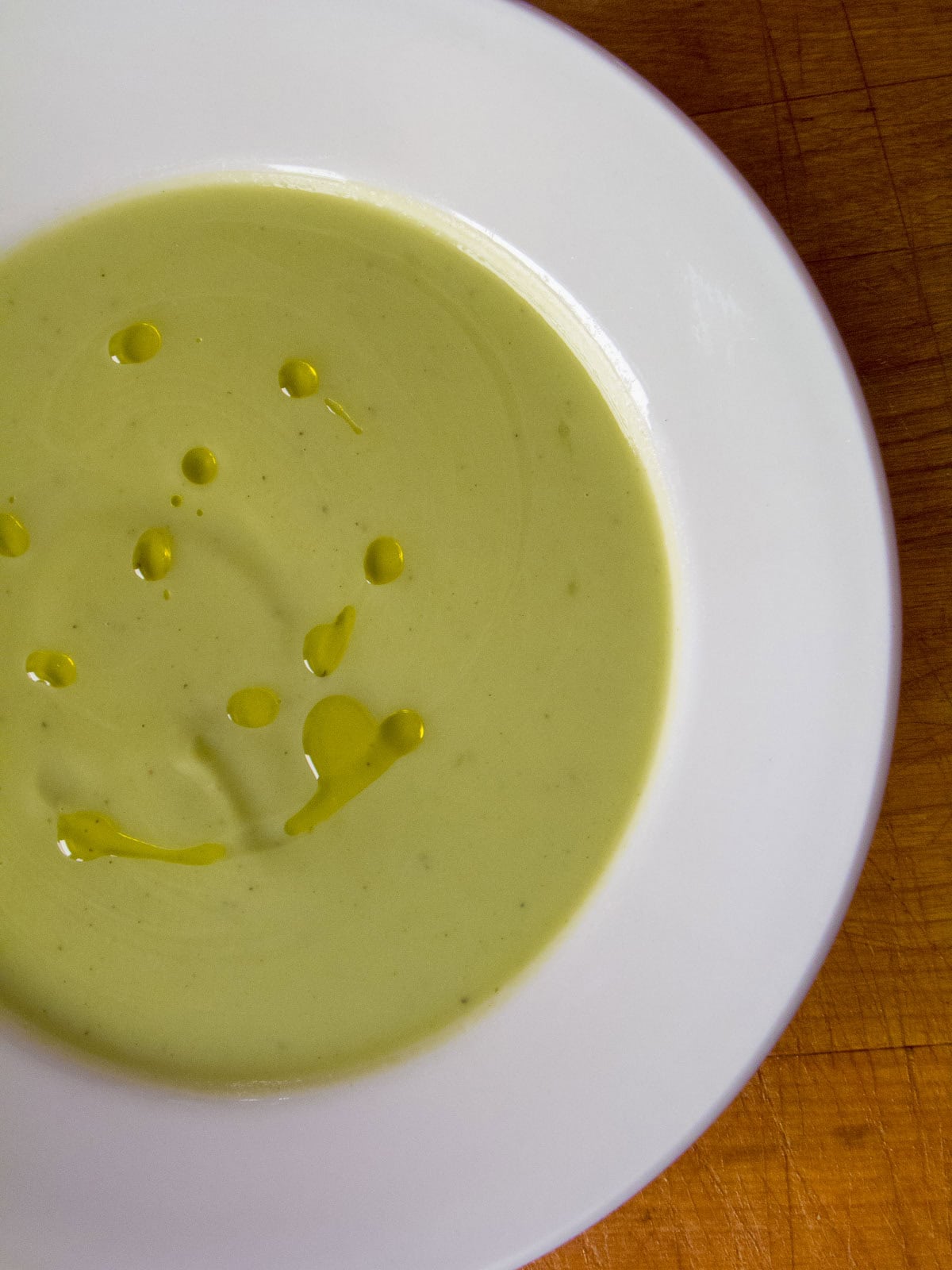 Easy broccoli soup with olive oil in a white bowl.