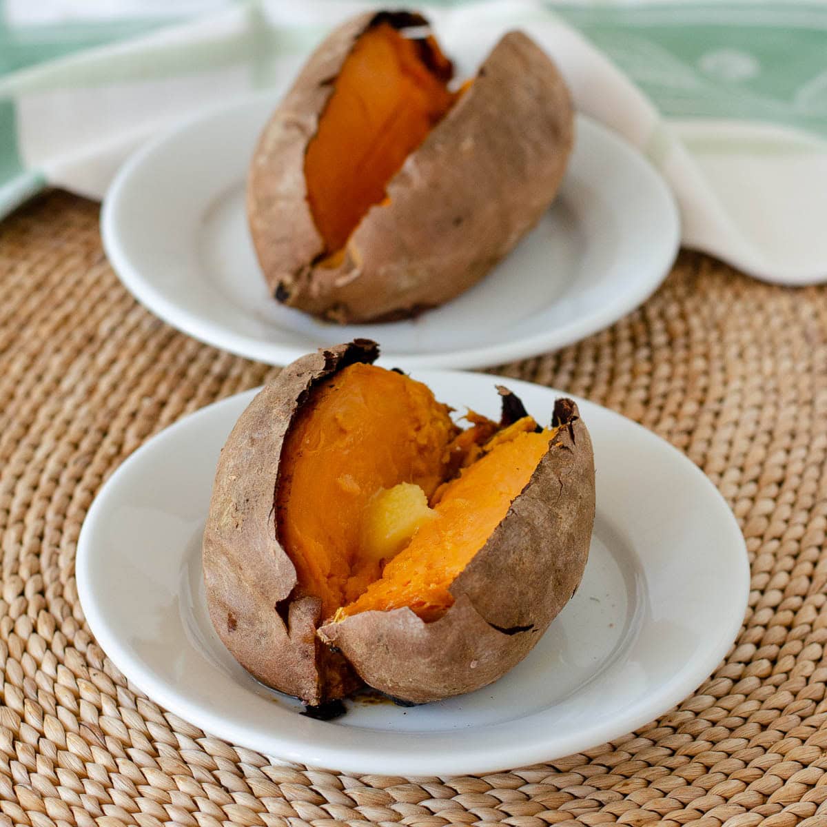 Baked sweet potatoes on white plates.